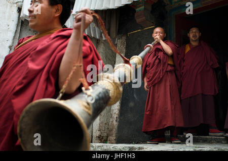 I monaci suonare la tromba tibetana all'interno del Monastero di Tashilumpo a Shigatse, nel Tibet, Cina. Foto Stock