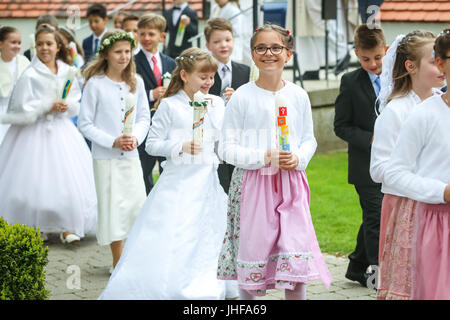 NANDLSTADT, Germania - 7 Maggio 2017 : i giovani ragazze e ragazzi portando candele accese e la voce per la Chiesa durante la loro prima Comunione in Nandlstadt, Germania. Foto Stock