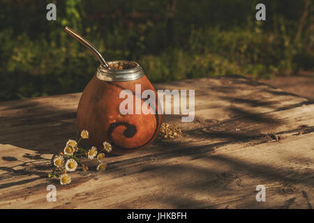 Argentino yerba mate bevanda in Calabash con Bombilla su uno sfondo di legno Foto Stock