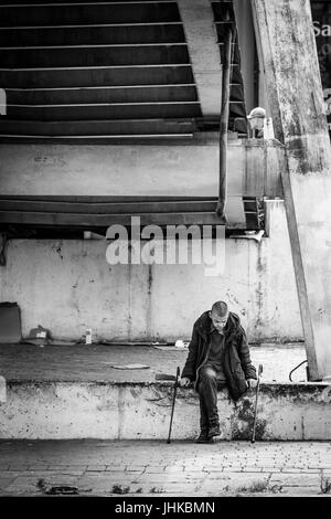 Senzatetto uomo sotto un ponte pedonale a Brewery Wharf, Leeds, West Yorkshire, Inghilterra. Foto Stock