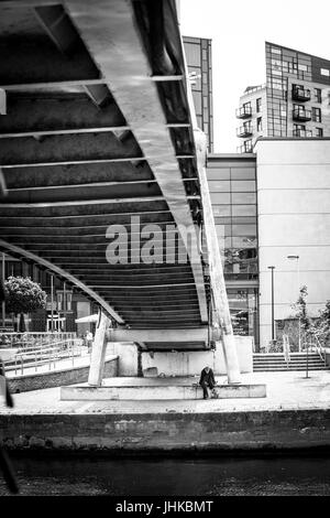 Senzatetto uomo sotto un ponte pedonale a Brewery Wharf, Leeds, West Yorkshire, Inghilterra. Foto Stock