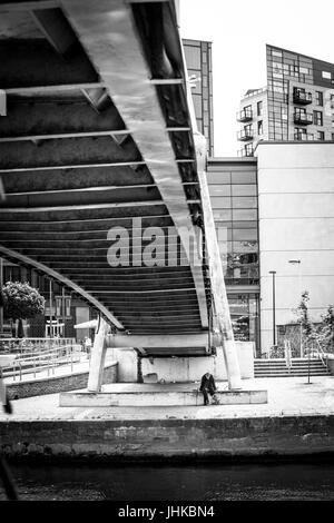 Senzatetto uomo sotto un ponte pedonale a Brewery Wharf, Leeds, West Yorkshire, Inghilterra. Foto Stock