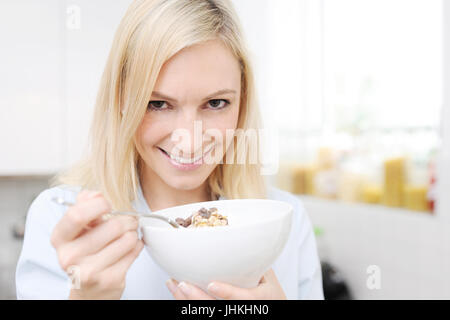 Donna allegra mangiare muesli al mattino Foto Stock