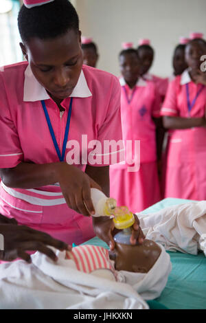 Una studentessa infermiera dimostrazione alla classe durante una sessione di formazione sulla rianimazione del bambino e l importanza di ABC. Foto Stock