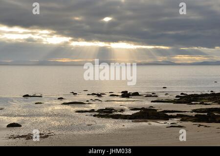 Di sera si rompe la luce del sole attraverso le nuvole scure su Dornoch firth a Portmahomack in Easter Ross, Scozia. Foto Stock