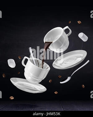 Volare con tazze di caffè nel bar. Set caffè su sfondo nero Foto Stock