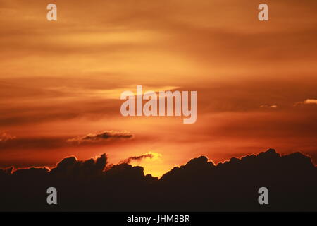 Arancione tramonto sopra le nuvole Foto Stock