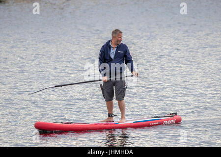 Southport, Merseyside, 14 luglio 2017. Regno Unito Meteo. Un radiatore molto grigio sera non smette di turisti diretti al molo e il lungomare, Stand Up Paddle Boarding, paddleboarding, paddle boarders surf a Southport nel Merseyside. Con pesanti acquazzoni di pioggia previsto persone erano desiderosi di fare la maggior parte del tempo a secco prima della pioggia arriva. Credito: Cernan Elias/Alamy Live News Foto Stock