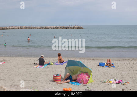 Turisti e residenti locali presso la spiaggia di San Marie de la Mer vicino alla regione della Camargue Arles nel sud della Francia Foto Stock