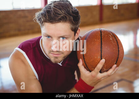 Chiusura del giocatore di basket tenendo palla mentre si pratica in tribunale Foto Stock