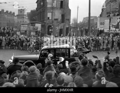 Il re Giorgio VI e la regina Elisabetta in un aperto auto passando attraverso il legame-danneggiato East End di Londra durante il loro Stae drive nella celebrazione delle nozze d'argento. Foto Stock