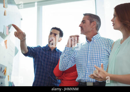 Gli affari seri persone per discutere sulla lavagna in ufficio Foto Stock