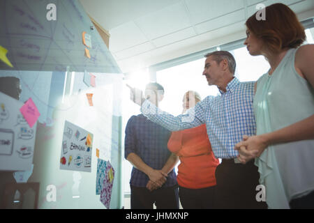 Basso angolo di vista business persone per discutere sulla lavagna in ufficio durante la giornata di sole Foto Stock