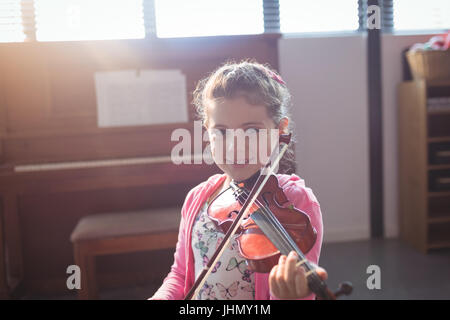 Ritratto di ragazza sorridente studente ripassando violino nella classe di musica Foto Stock