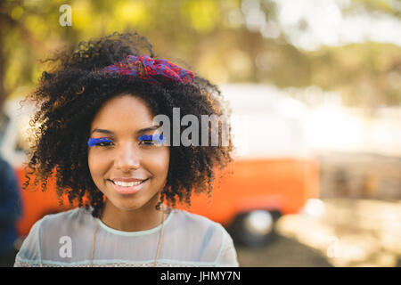 Close up ritratto di donna che indossa ciglia artificiali mentre si sta in piedi sul campo Foto Stock