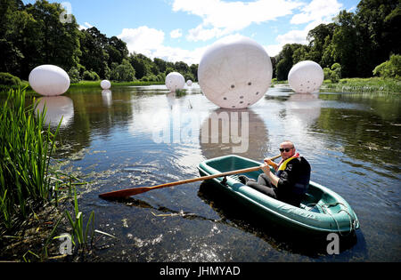 Artista Steve Messam righe la sua barca attraverso 'Scattered', uno dei suoi tre grandi installazioni gonfiabile che viene svelato durante l'apertura delle frontiere Sculpture Park vicino a Kelso. Foto Stock