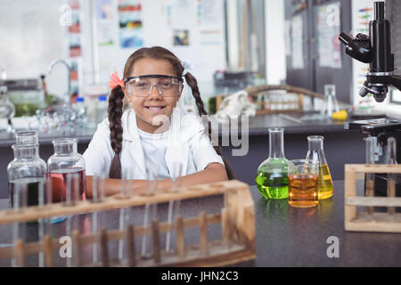 Ritratto di studente elementare di indossare degli occhiali di protezione da banco in laboratorio di scienze Foto Stock