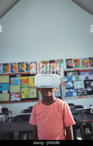 Ragazzo che indossa la realtà virtuale simulatore in aula Foto Stock