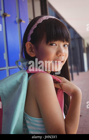 Ritratto di ragazza con zaino in corridoio a scuola Foto Stock