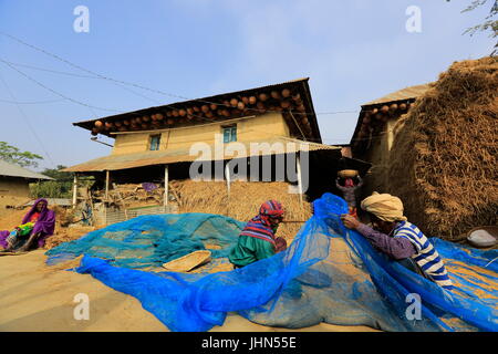 Gli agricoltori sono di misura risone raccolto nella parte anteriore di una tradizionale casa rurale nel Nachole upazila di Chapainawabganj, Bangladesh Foto Stock