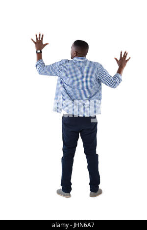 Vista posteriore dell'uomo fingendo di toccare una schermata invisibile contro uno sfondo bianco Foto Stock