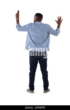Vista posteriore dell'uomo fingendo di toccare una schermata invisibile contro uno sfondo bianco Foto Stock