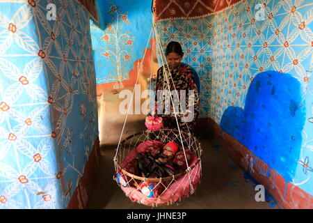 Una madre e un bambino all'interno di una casa di villaggio Tikoil in Nachole upazila di Chapainawabganj distretto del Bangladesh. Più di cinquanta case in questa villa Foto Stock