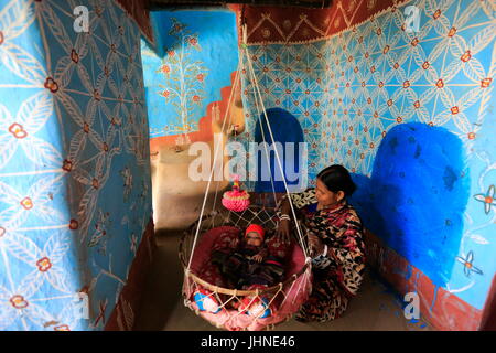 Una madre e un bambino all'interno di una casa di villaggio Tikoil in Nachole upazila di Chapainawabganj distretto del Bangladesh. Più di cinquanta case in questa villa Foto Stock