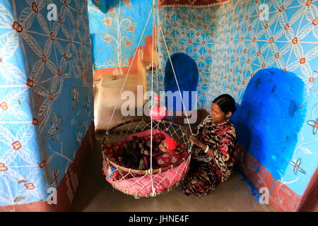 Una madre e un bambino all'interno di una casa di villaggio Tikoil in Nachole upazila di Chapainawabganj distretto del Bangladesh. Più di cinquanta case in questa villa Foto Stock