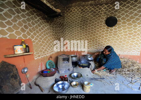 Una donna cuochi dentro la sua casa al villaggio Tikoil in Nachole upazila di Chapainawabganj distretto del Bangladesh. Più di cinquanta case in questo villaggio un Foto Stock