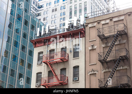 Cellulare antenne su un basso edificio ad angolo edificio appartamento attico in Midtown East New York City, NY, Stati Uniti Foto Stock