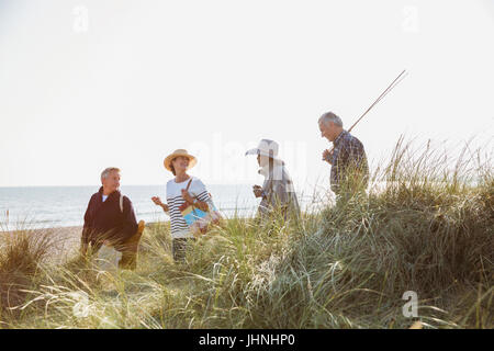 Coppie senior con canna da pesca a piedi in sunny beach erba Foto Stock