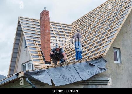 Maschio di falegnami di riparare il tetto della casa. Foto Stock