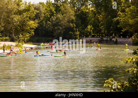 L apprendimento dei bambini l imbarco a pale sul fiume Tago / Tajo come fluisce attraverso i giardini reali in Aranjuez Nella provincia di Madrid di Spagna Foto Stock