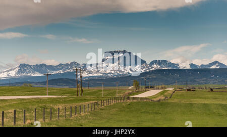 Prairie i terreni agricoli e le turbine eoliche all'ombra delle montagne rocciose Alberta Canada Foto Stock