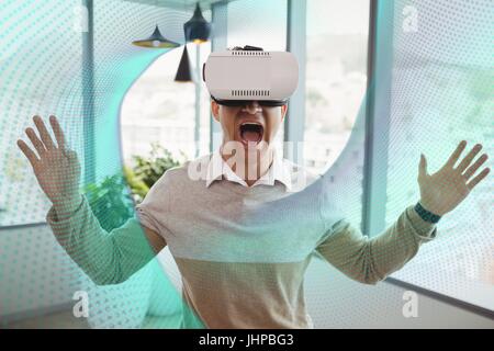 Composito Digitale dell uomo eccitato in cuffia VR cercando in interfaccia Foto Stock