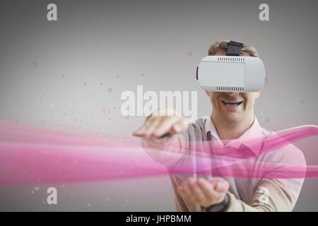 Composito Digitale dell uomo in cuffia VR toccando luce rosa contro uno sfondo bianco Foto Stock