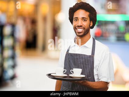 Composito Digitale del proprietario del ristorante con tazzine di caffè contro lo sfondo sfocato Foto Stock