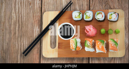 Close up di sushi servita sul tagliere contro di close-up di texture in legno Foto Stock