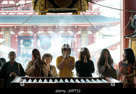 Le donne in preghiera presso il Tempio di Senso-ji. Aprile 14, 2014 - Tempio di Asakusa, Tokyo, Giappone Foto Stock
