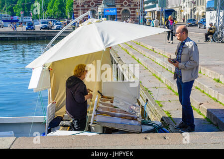 HELSINKI, Finlandia - 16 giugno 2017: Scena del porto del sud Piazza del Mercato, con un venditore di pesce su una barca, shopper e altri visitatori, a Helsinki, Fin Foto Stock