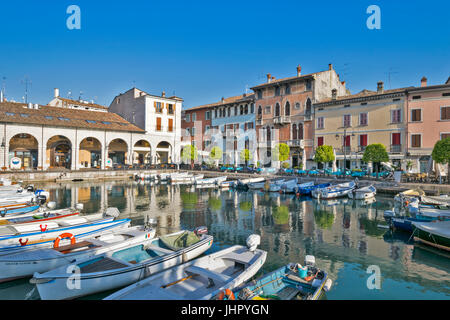 Italia Lago di Garda DESENZANO DEL GARDA MORNINGTHE precoce del porto con barche e ristoranti circostanti in aprile Foto Stock