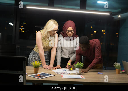 Colleghi di lavoro straordinario nel loro ufficio. La lavorazione di un turno di notte in ufficio. Foto Stock