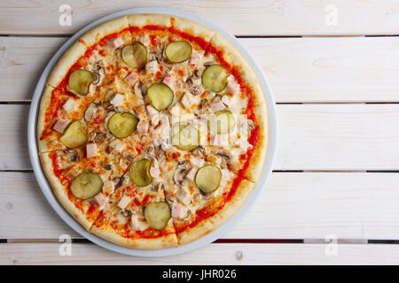 Vista superiore della pizza col prosciutto e cetriolo sottaceto Foto Stock