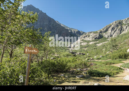 Cartello in legno che puntano a Lac de Melu su una pista escursioni nelle montagne del Restonica vicino a Corte in Corsica centrale Foto Stock