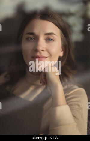 Ritratto di donna sorridente rilassante nel salotto di casa Foto Stock