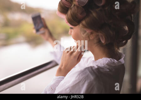 Sposa tenendo selfie dal telefono mobile a casa Foto Stock