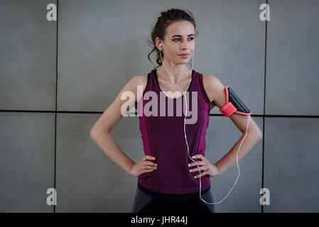 Montare la donna in piedi in studio fitness Foto Stock