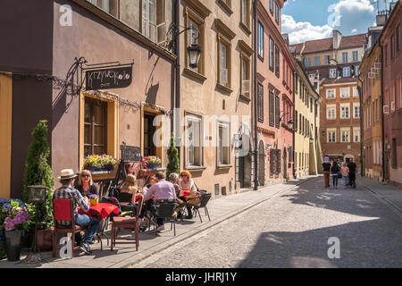 Turisti che si siedono nella luce del sole al di fuori Krzywe Kolo Cafe, Città Vecchia, Varsavia, Polonia Foto Stock