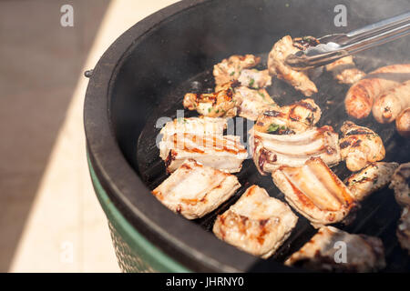 Cibo, picnic, ricette e concetto di carne - primo piano su di una deliziosa cucina costolette di maiale padella per grigliare lungo con le salsicce, pezzi di tornitura anche per la tostatura Foto Stock
